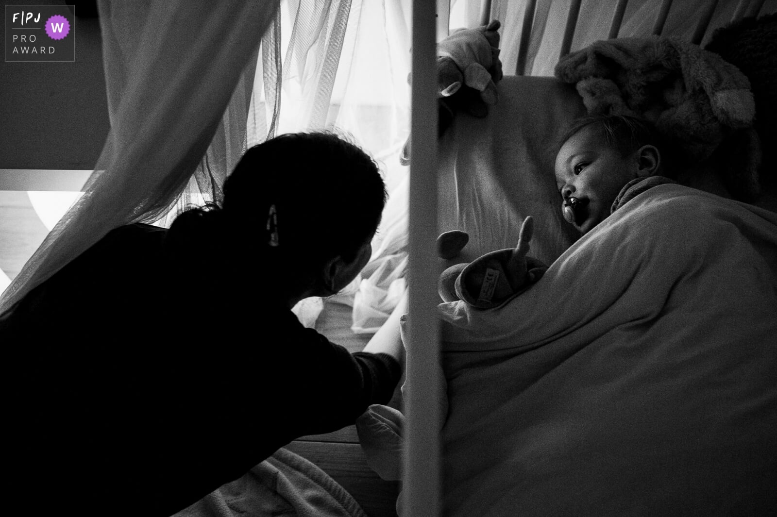 mama legt kind te slapen tijdens day in the life fotoreportage