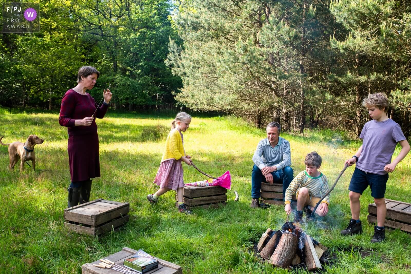 Familie in Vlaanderen die geniet van een kampvuur tijdens een gezinsreportage op locatie