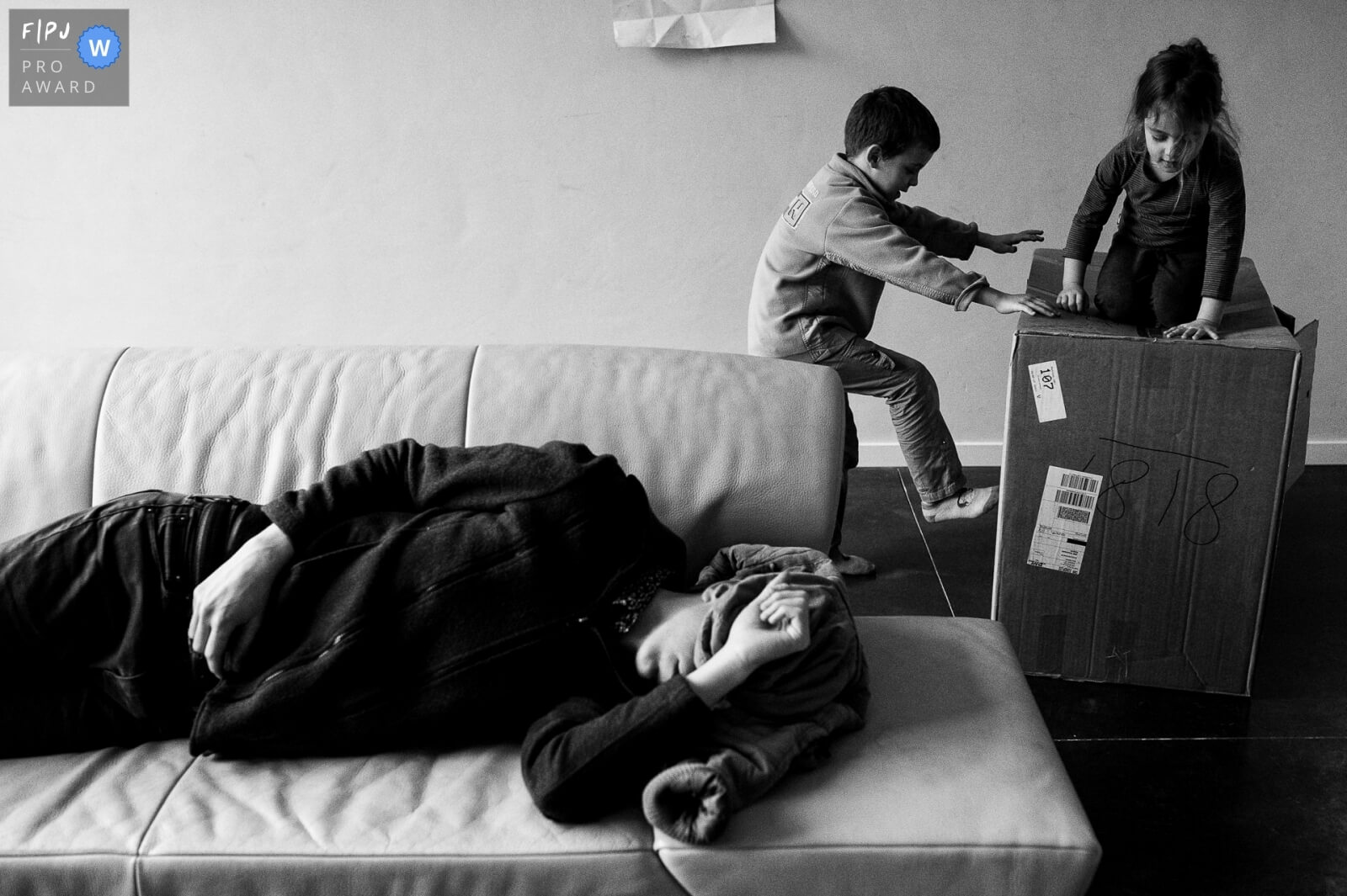 day in the llife foto van kinderen die spelen met een doos terwijl een ouder probeert te slapen in de zetel