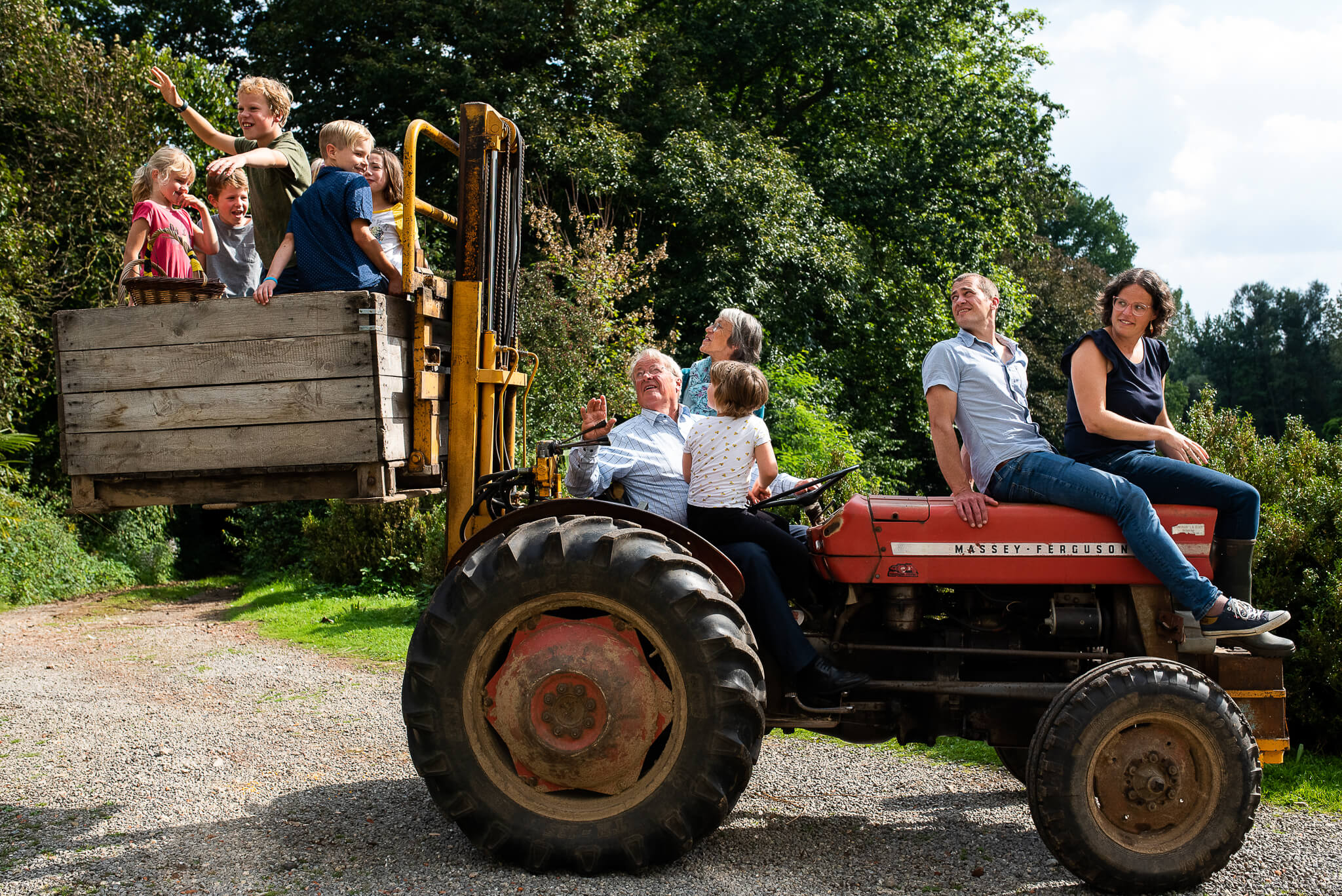 opa op tractor met kleinkinderen in bak achteraan tijdens fotoshoot